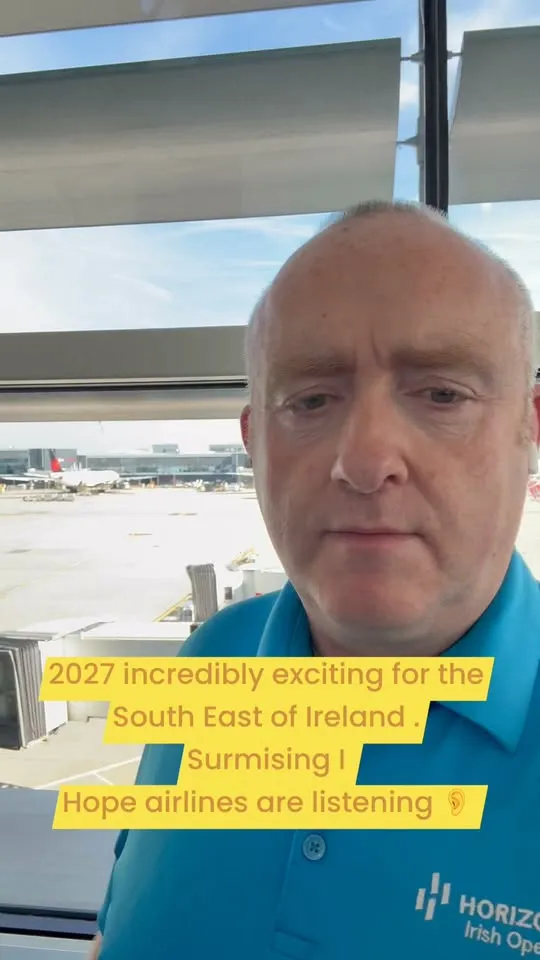 Tom Britton at an airport window, planes behind him
