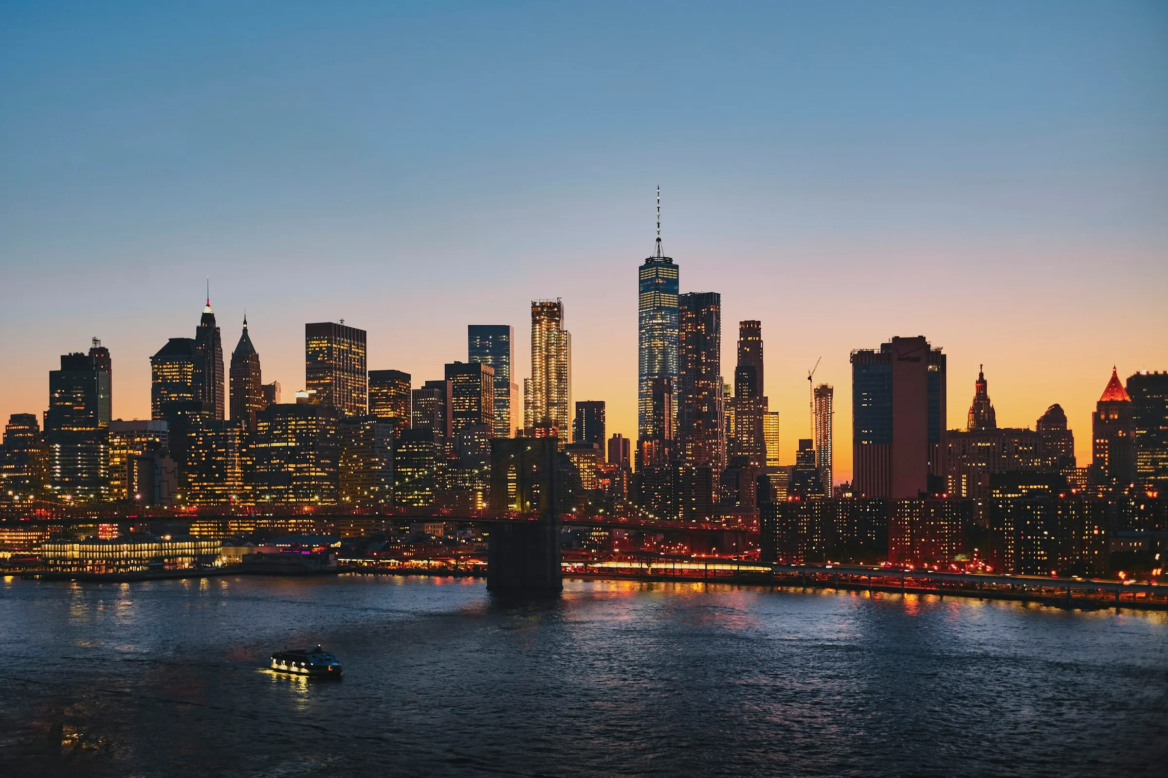 Manhattan skyline at dusk with the Brooklyn Bridge